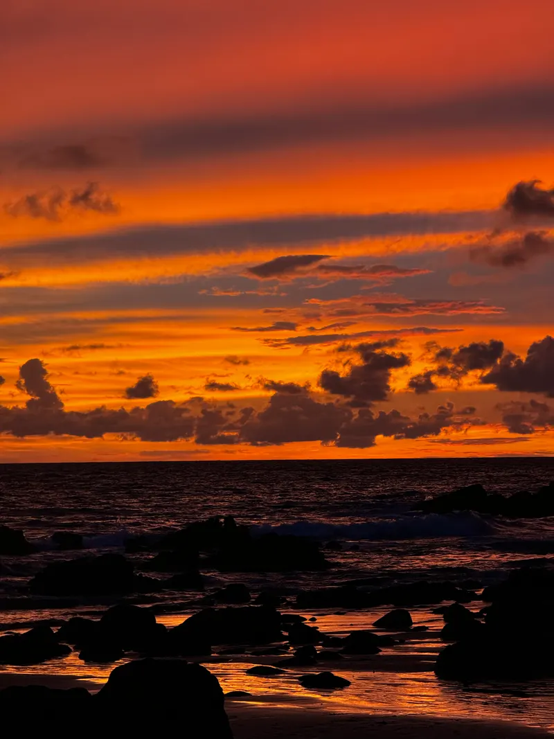 Sunset over the rocks at Nai Thon Beach, the sky in orange bands