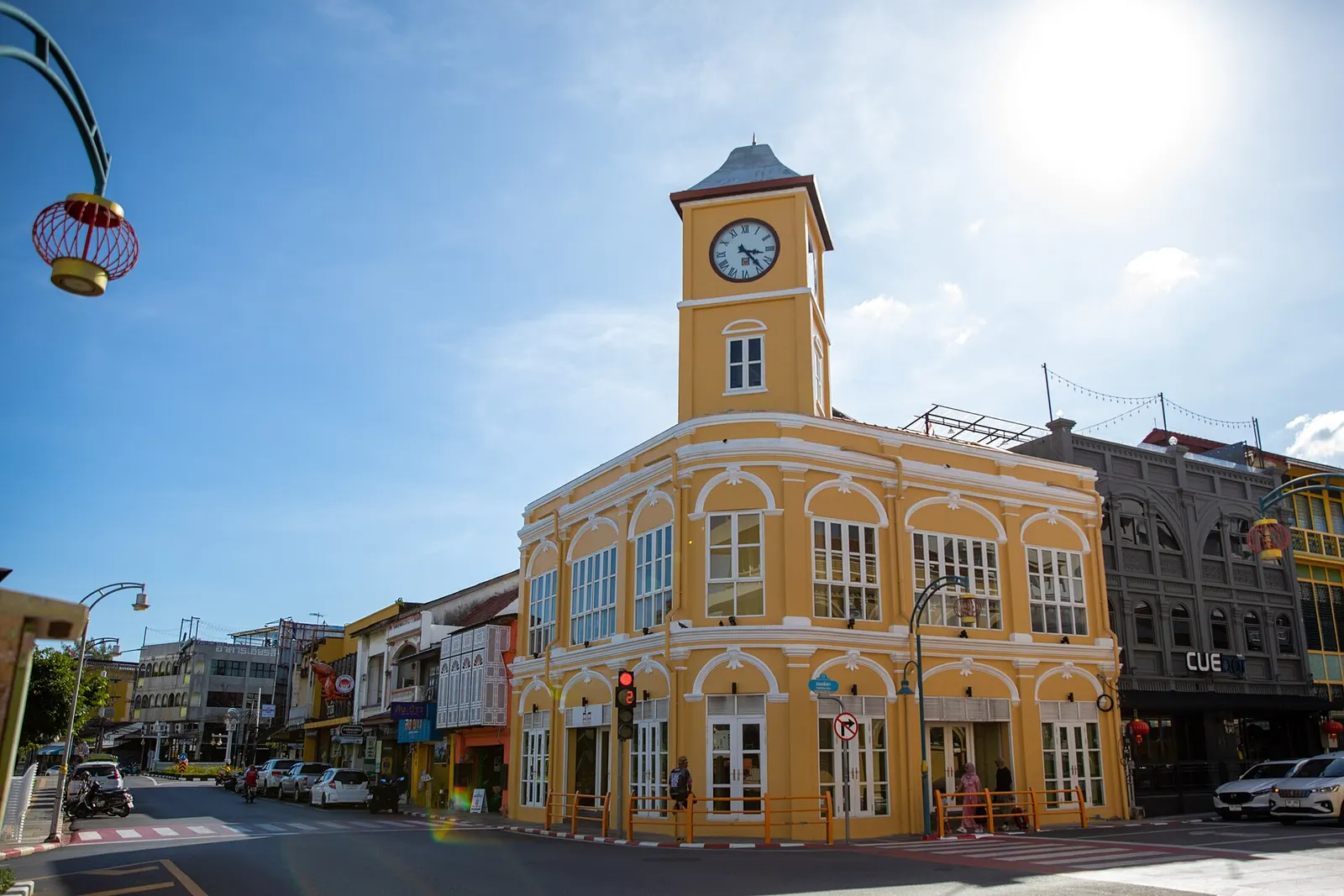 The yellow clock tower and arched Sino-Portuguese shophouses of Phuket Old Town under a blue sky