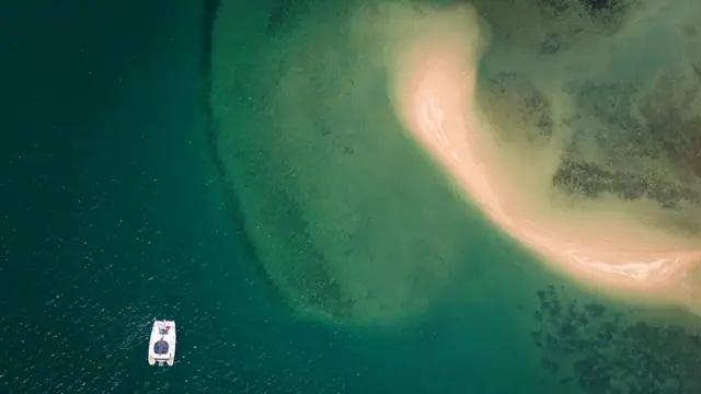 Lagoon 56 OO7 — aerial view by a sandbar